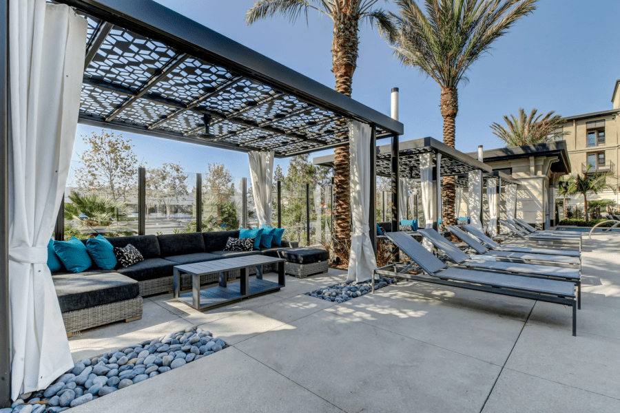 poolside lounge area with covered couches and long daybeds