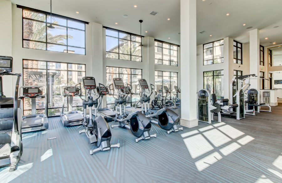 alternate view of fitness center with strength training equipment, cardio machines, and free weights